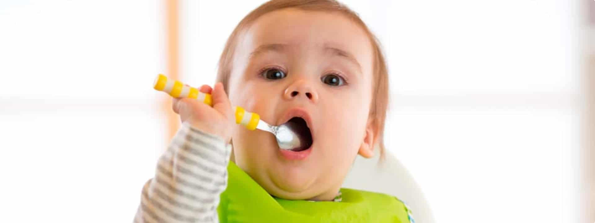 תינוק מכניס כפית לפה