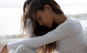 אישה יושבת ותופסת את הראש שלה