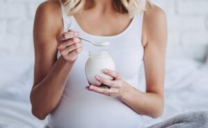 אישה בהריון אוכלת יוגורט