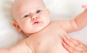 תינוקת שוכבת על הגב ועושים לה מסאג' בבטן