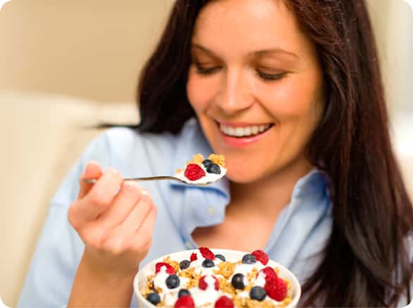 אישה אוכלת יוגורט עם פירות