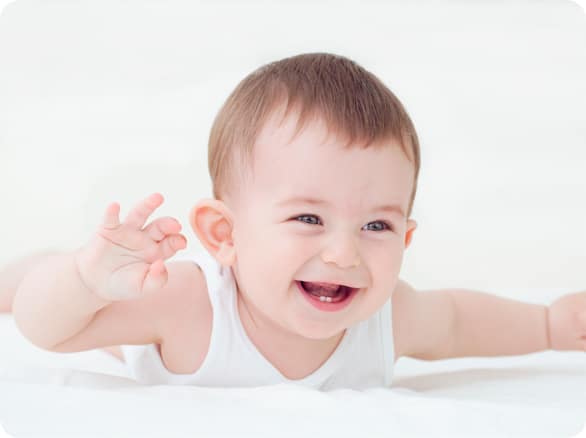 תינוק שוכב על הבטן ומחייך