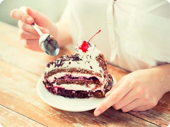 אישה אוכלת פרוסת עוגה