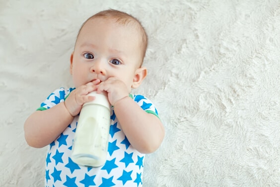 תינוק שותה בקבוק חלב