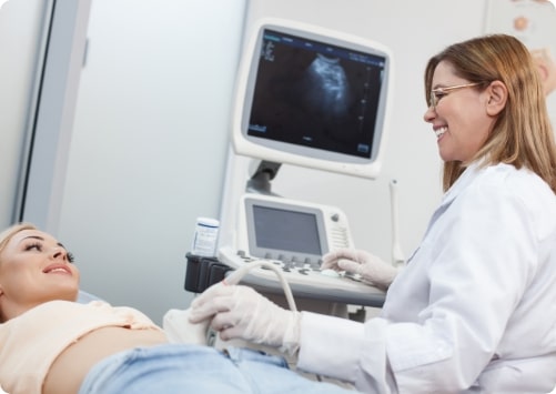 אישה בהריון נמצאת בבדיקת אולטרסאונד אצל רופאה
